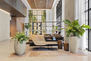 Relax in a serene space with a large sofa, lush greenery, and a view of the outdoors.