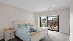 Ein Schlafzimmer mit Bett, Nachttischen und Blick ins Freie.