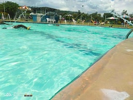 Una piscina con acqua cristallina, circondata da sdraio e ombrelloni.