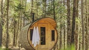 Een houten blokhut met een rond ontwerp, een klein raam en een deur.
