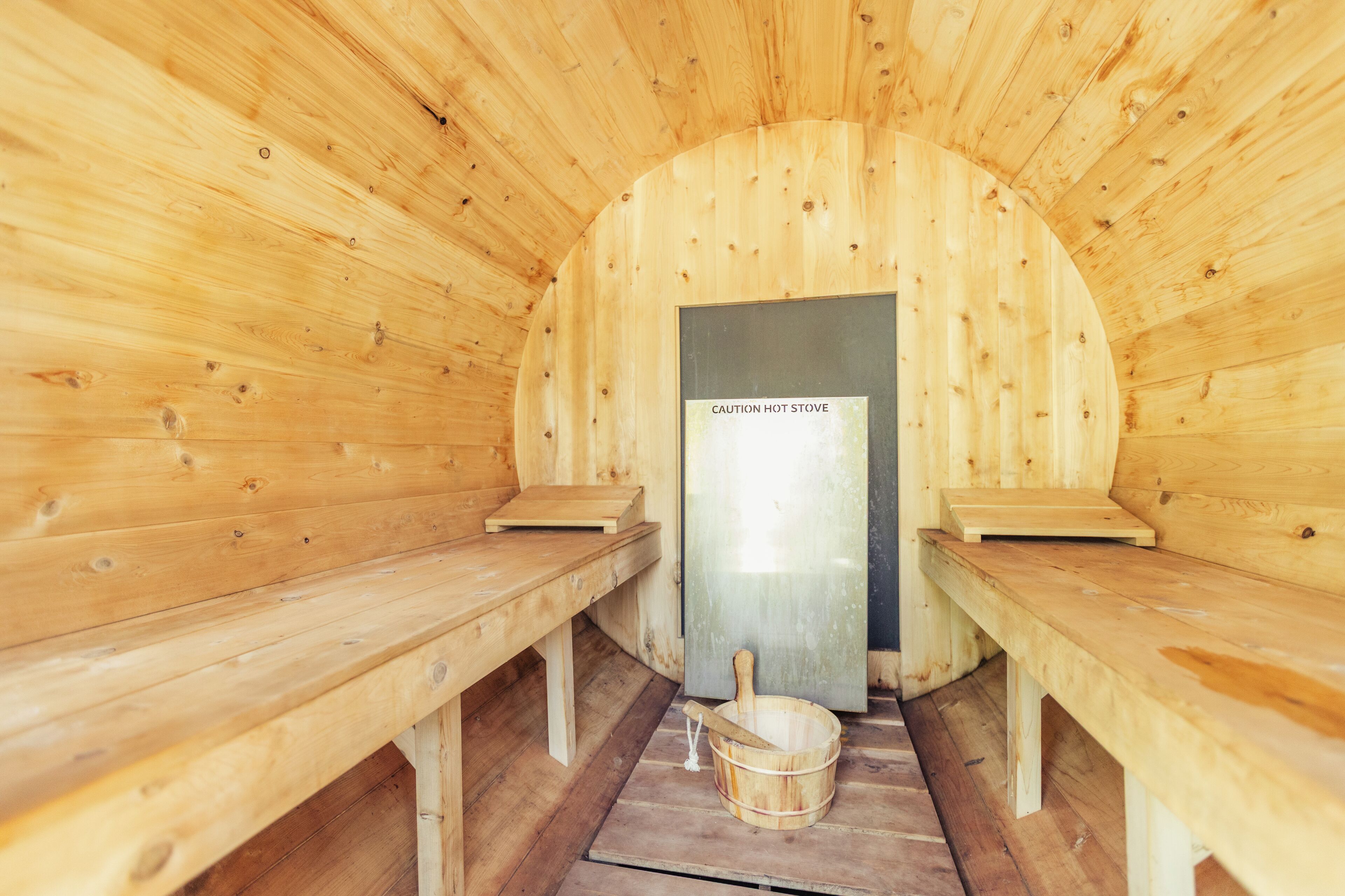A sauna with wooden benches and a caution sign on the door.