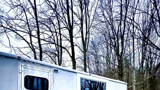 A white RV parked on a gravel path with a 'WELCOME' sign at the entrance. - Custom HorseTrailerTinyHome near Grayson Highlands (Mouth of Wilson)