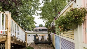 A narrow pathway leading to a wooden staircase with a white picket fence on one side and a blue garage door on the other. - StoneFly Studio at Dragonfly Flats  Creede, Co (Creede)