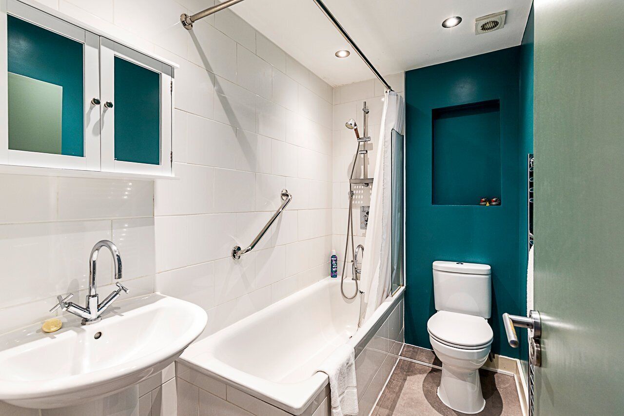 Une salle de bain avec un lavabo blanc, une baignoire et des toilettes.