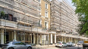 A building with multiple floors, some balconies, and a street in front with parked cars. - Stylish Bayswater Flat with Outdoor Space (London)