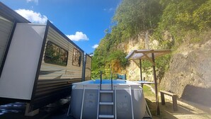 Un espace de loisirs comprenant une piscine, un espace de repos couvert et une remorque.