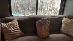 Un canapé avec un panier en osier contenant des serviettes.