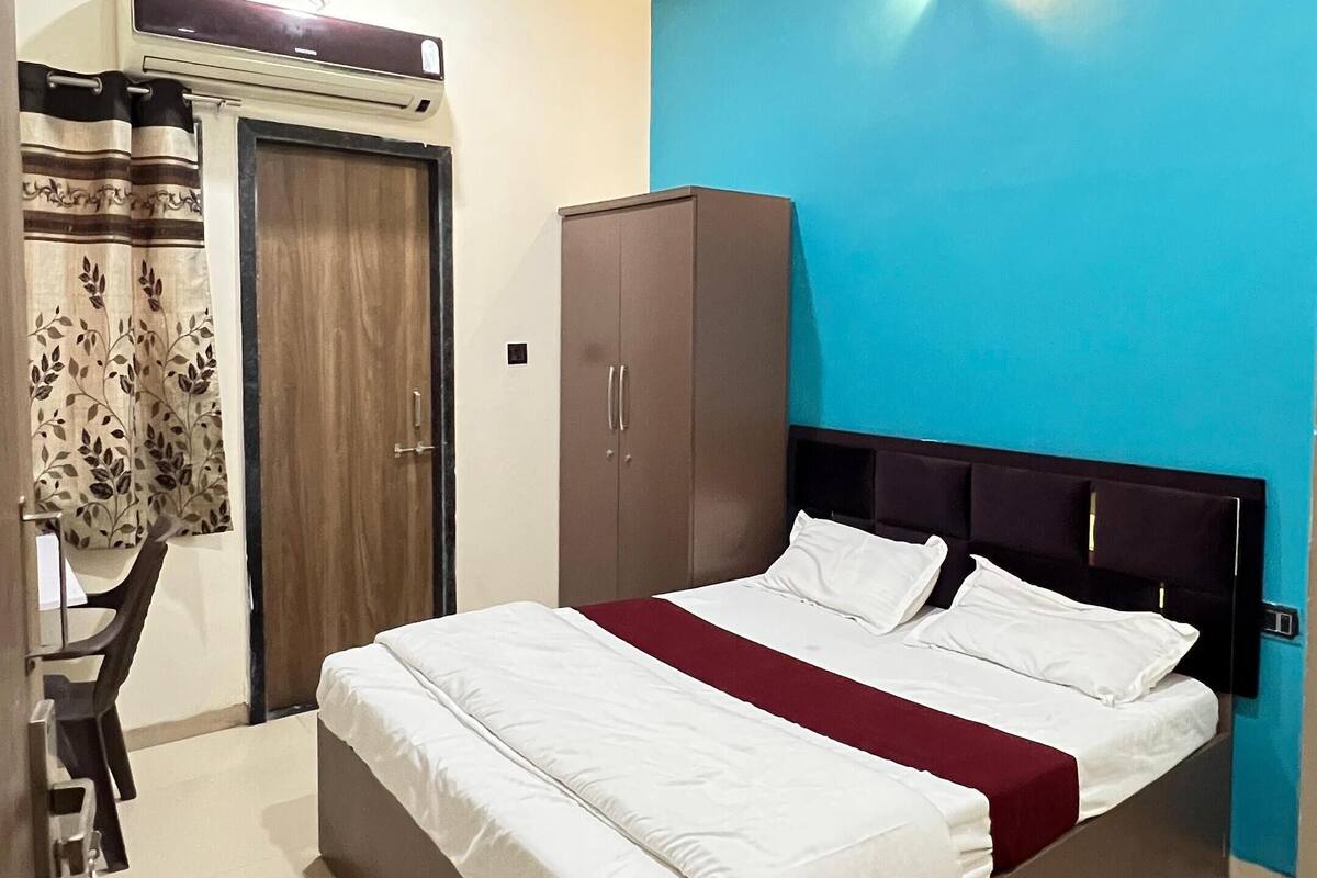 A bedroom with a bed, wardrobe, and a ceiling fan.