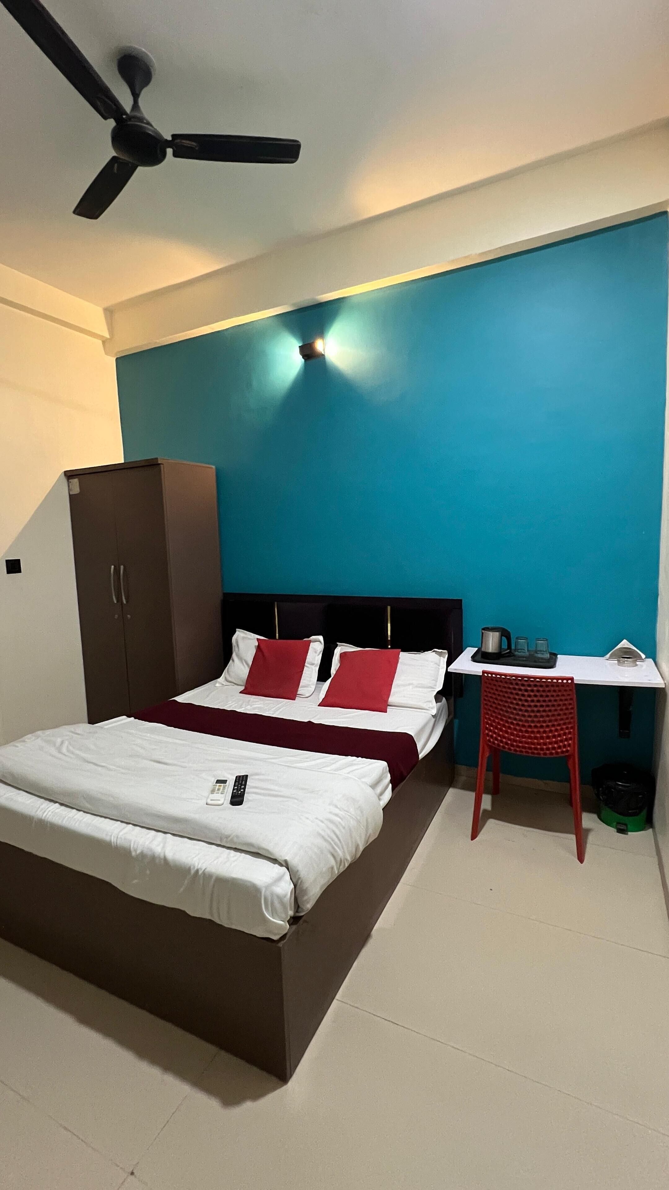Une chambre à coucher comprenant un lit, un bureau, une chaise, une armoire et un ventilateur de plafond.