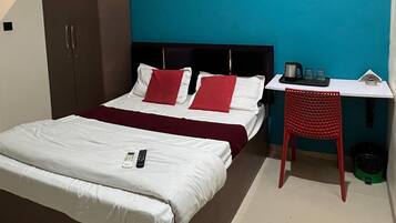 Une chambre à coucher comprenant un lit, un bureau, une chaise, une armoire et un ventilateur de plafond.