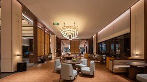 A modern hotel lobby with a central round table, seating areas, and a large chandelier. - Madison Hot Spring Hotel Jian Wugong Mountain (Ji'an)