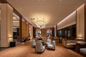 A modern hotel lobby with a central round table, seating areas, and a large chandelier. - Madison Hot Spring Hotel Jian Wugong Mountain (Ji'an)