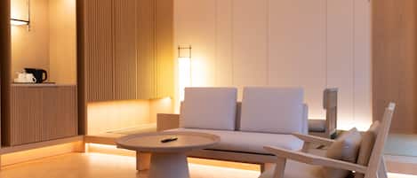 Una sala de estar moderna con una mesa de centro redonda, un sofá y una silla.