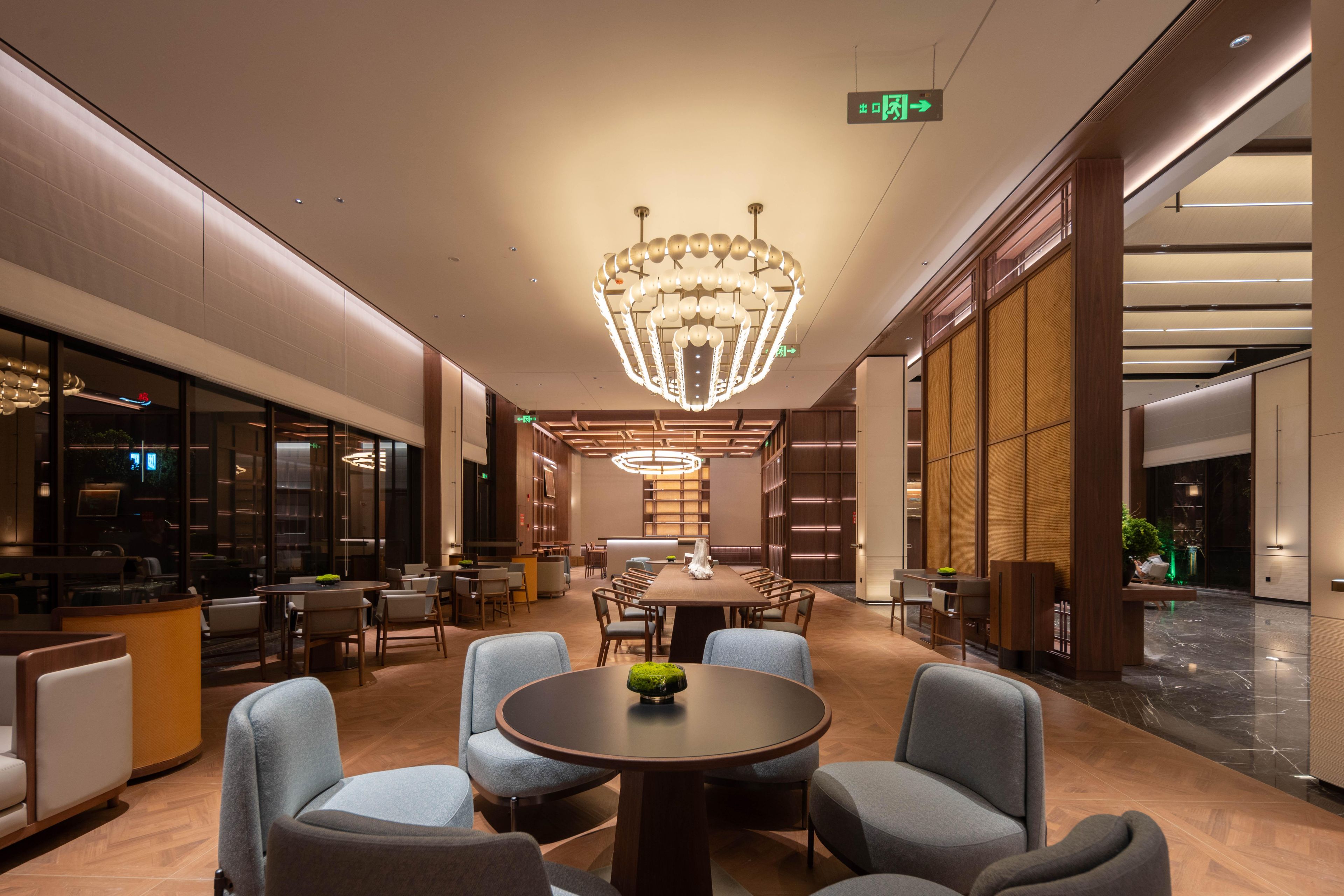 A spacious lobby with a large chandelier, comfortable seating, and a reception area.