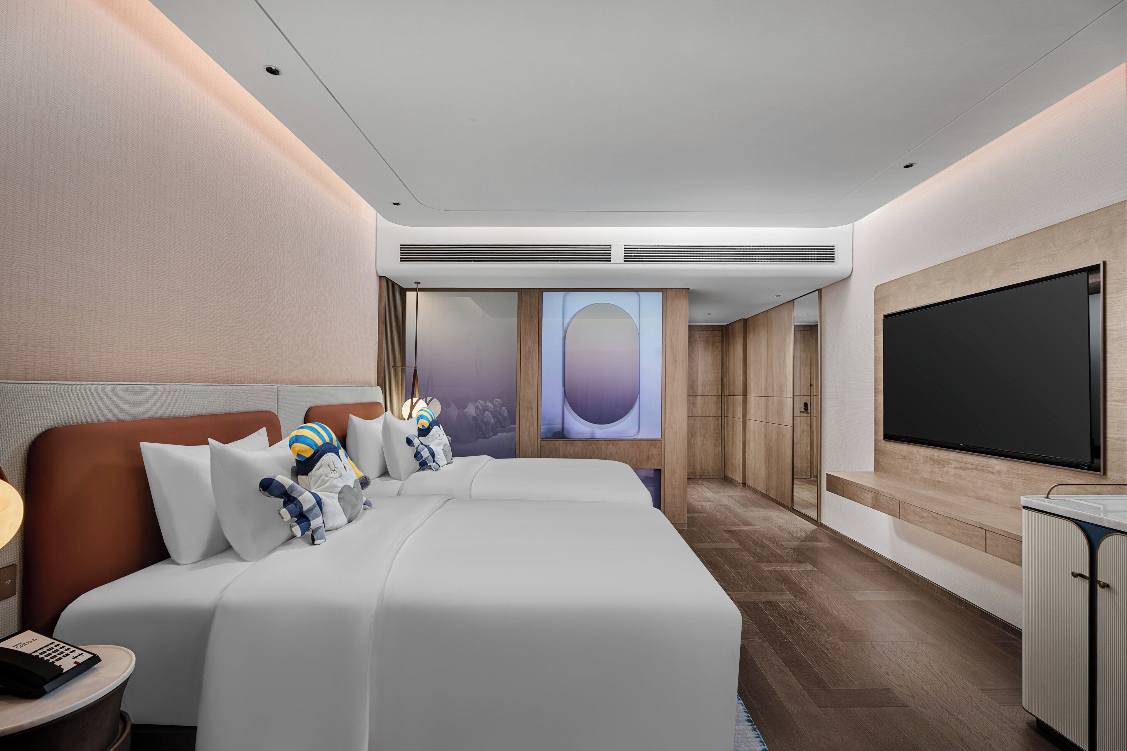 Une chambre d’hôtel moderne équipée d’un grand lit, d’une télévision et d’un mini-bar.