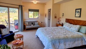 Une chambre avec un grand lit, un canapé, un fauteuil et une petite table.