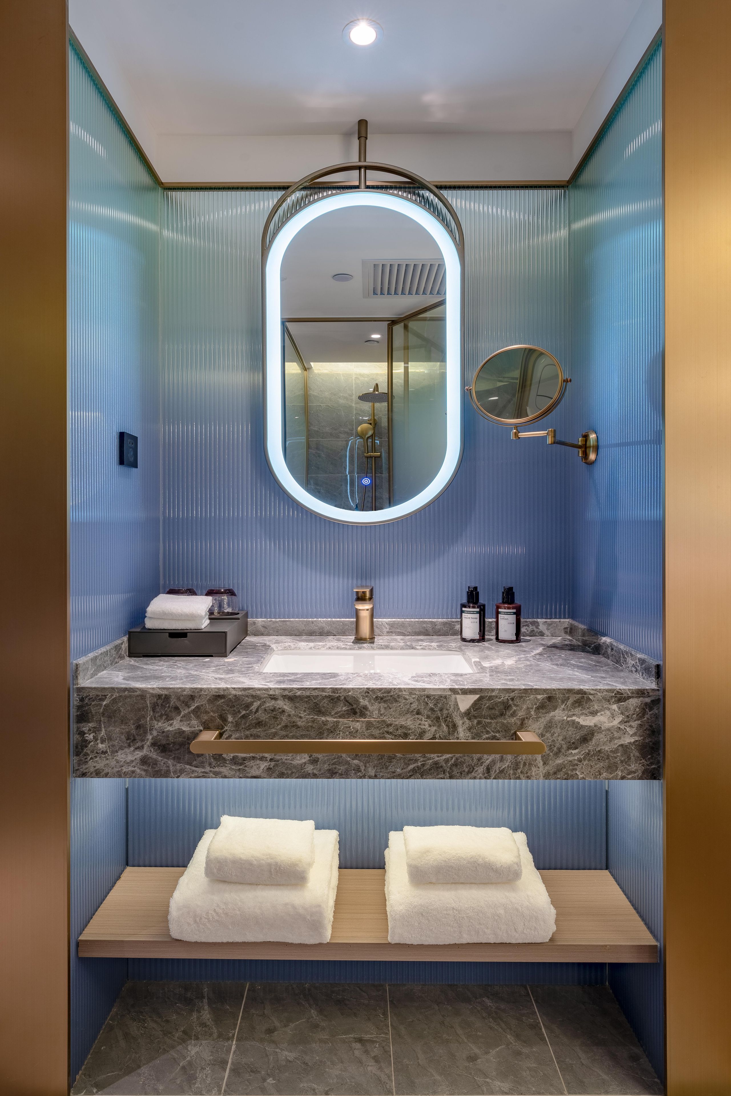 Une salle de bain avec un lavabo en marbre, un miroir et un porte-serviettes.
