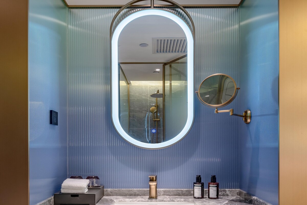 Une salle de bain avec un lavabo en marbre, un miroir et un porte-serviettes.
