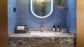 Une salle de bain avec un lavabo en marbre, un miroir et un porte-serviettes.