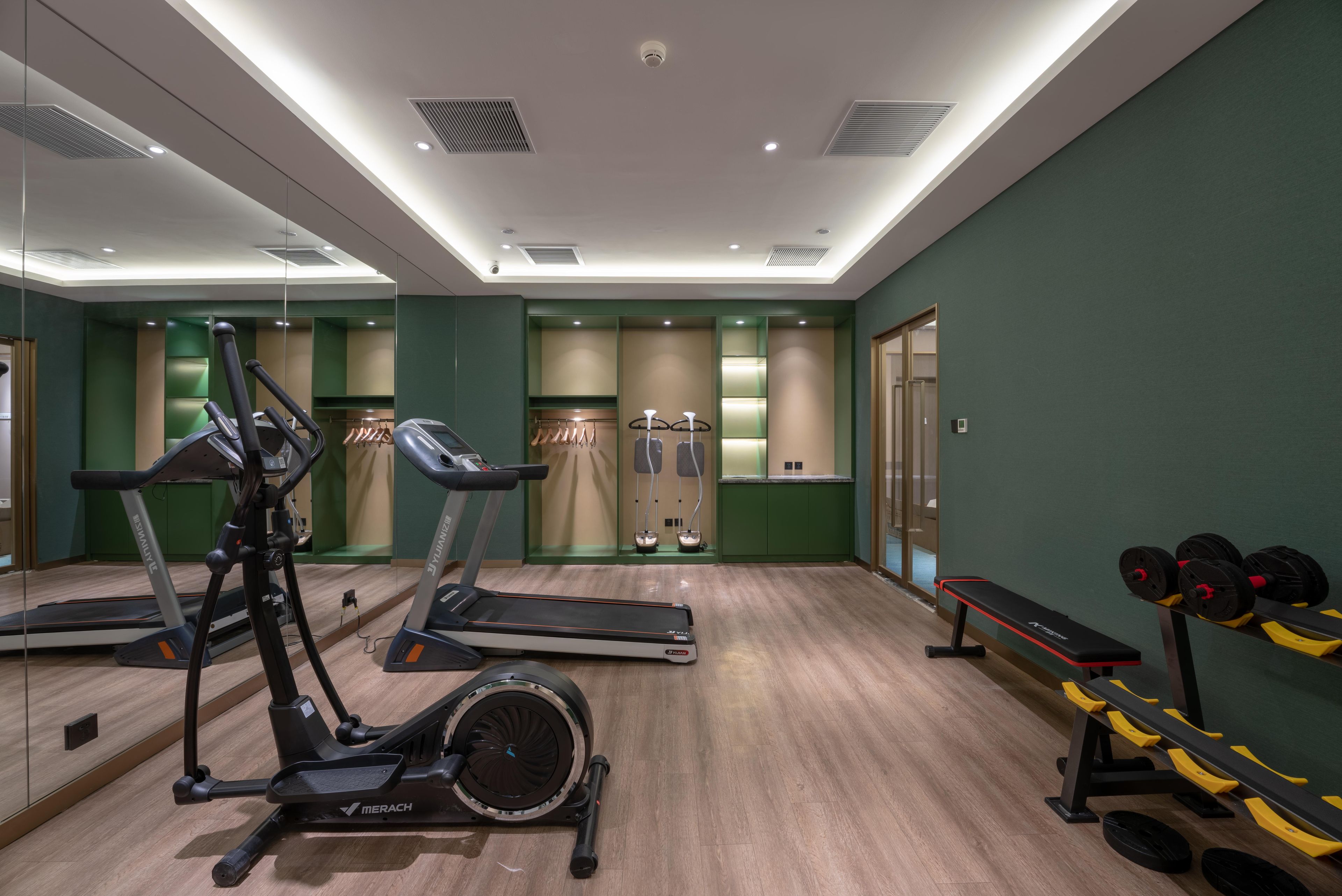 Una palestra con attrezzature per esercizi, uno specchio e una panca.