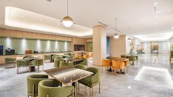 A spacious hotel lobby with multiple seating areas, a reception desk, and a modern design.