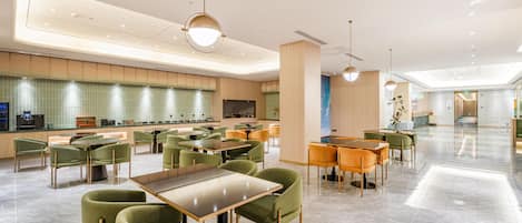 A spacious hotel lobby with multiple seating areas, a reception desk, and a modern design.