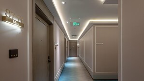 Et hotelmøde med blåt tæppe, et skilt med nummer 8717, og en nødudgangsskilte.