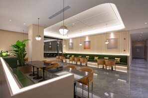 Un restaurante moderno con una zona de asientos en cabinas verdes, una barra y lámparas colgantes.