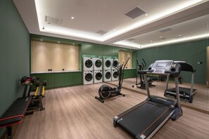 Un gimnasio con cinta de correr, elíptica y máquinas de pesas.