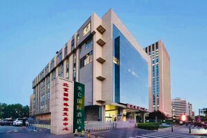 A modern building with signage indicating it is a hotel. - Madison Hotel Beijing Olympic Center Bird's Nest (Beijing)