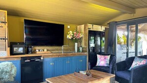 A compact living space with a kitchen area, a dining table, and a sofa.