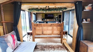 A cozy room with a wooden bed, a small table, and a bench.
