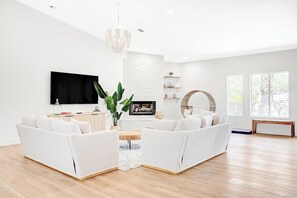 Smart TV, lareira, livros, videoteca