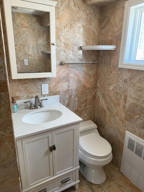 Bathroom features a sink, toilet, and mirror.