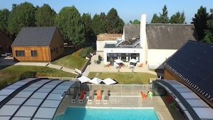 A swimming pool with lounge chairs and umbrellas, surrounded by buildings and trees. - Beautiful Family Apartment in Amboise (Amboise)