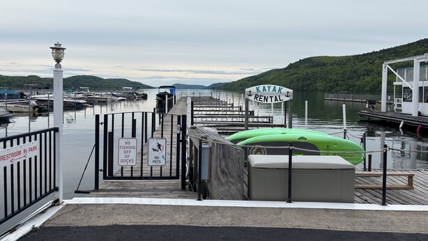 A kayak rental dock with a sign, a no fishing sign, and a no pets sign.
