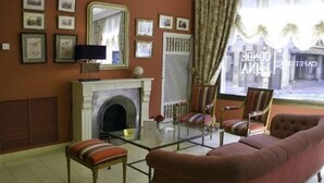A living room with a fireplace, a sofa, a glass coffee table, and framed pictures on the wall. - Barceló León Conde Luna (León)