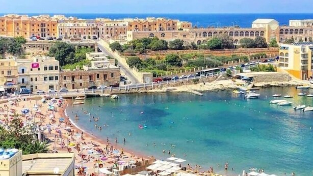 Une ville côtière dotée d’une plage, de bateaux et de bâtiments historiques.