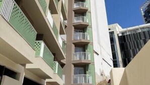 Un immeuble de grande hauteur, à plusieurs étages, doté de balcons.