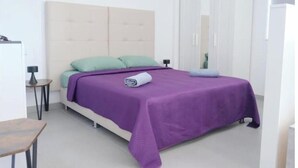 Une chambre à coucher comprenant un lit, une table de chevet, une chaise et une armoire.