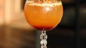 Een cocktail in een longdrinkglas, versierd met gedroogd fruit en een kers.