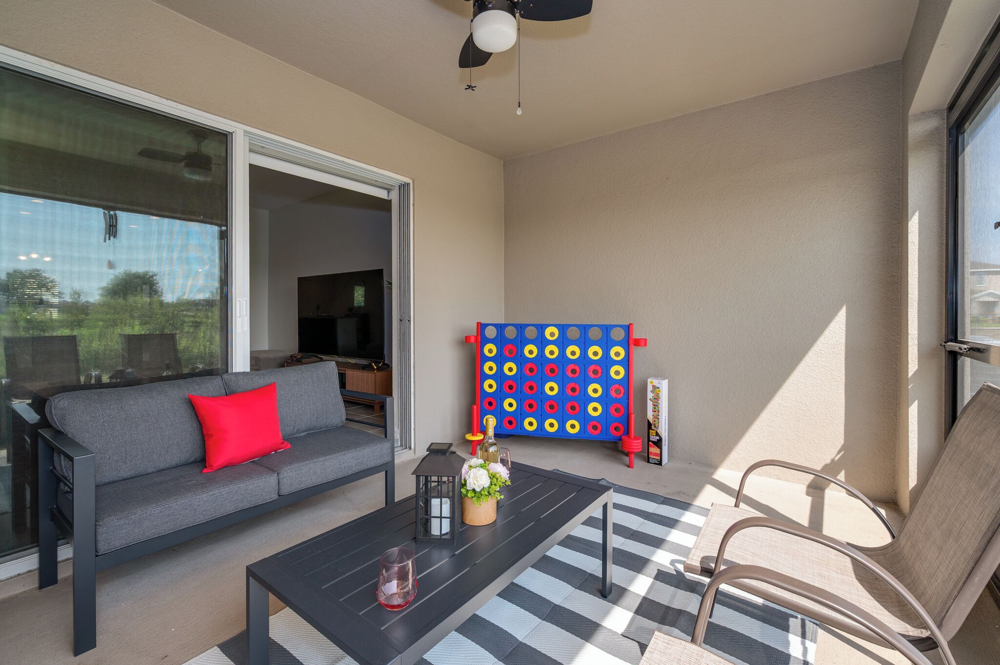 A modern living room with a gray sofa, a black coffee table, and a checkered rug.