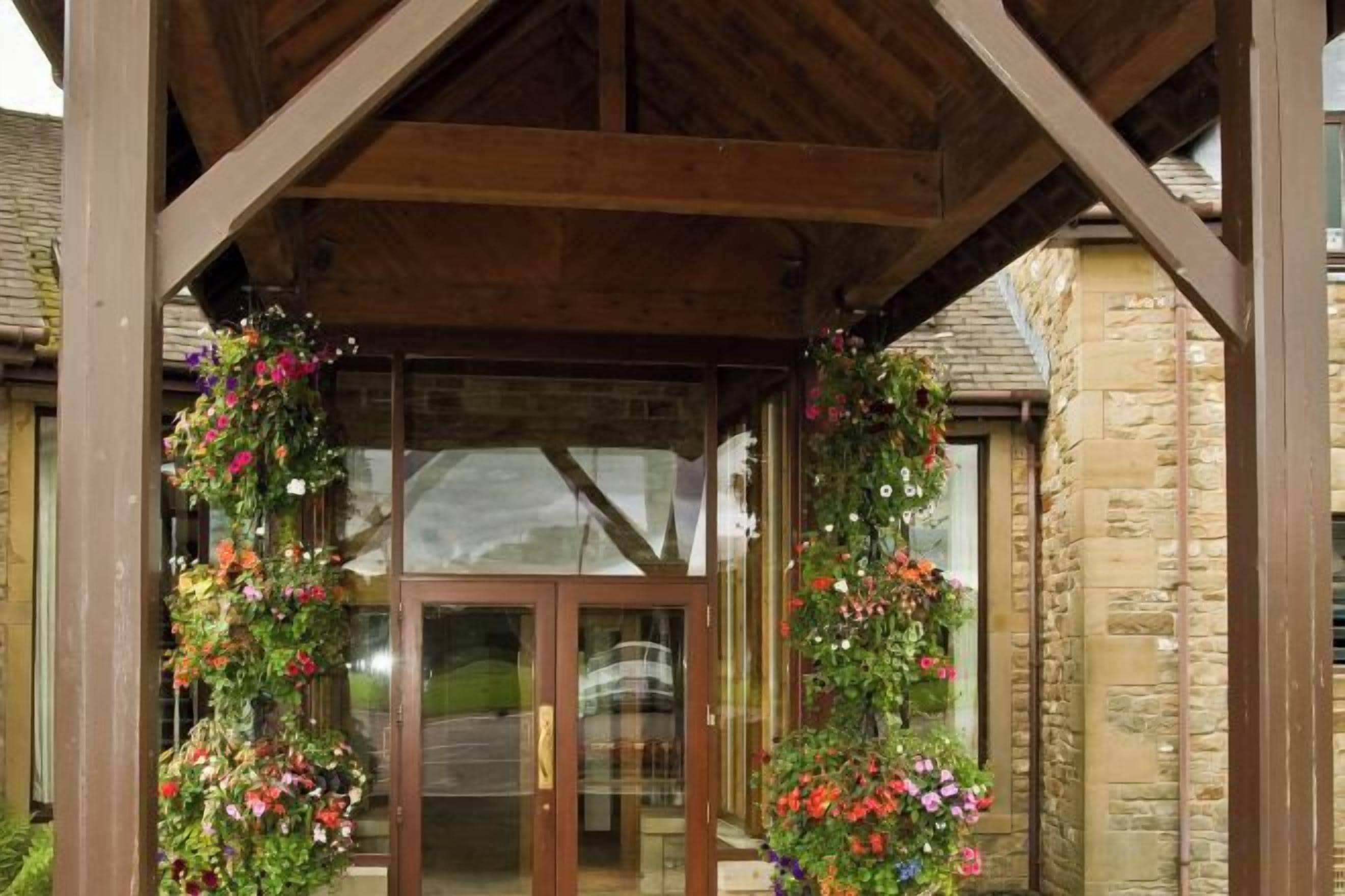 A wooden structure with a glass door entrance, surrounded by stone walls.