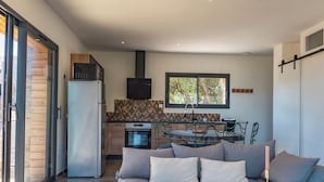 Ein zeitgemäßer Wohnbereich mit Sofa, Esstisch und Küchenzeile.