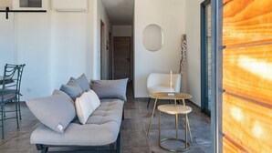 Ein modernes Wohnzimmer mit einem grauen Sofa, einem kleinen runden Tisch und einem Sessel.