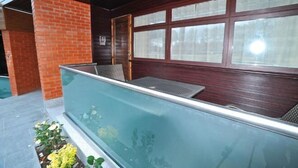 A balcony with a glass barrier, a brick wall, and a window with frosted glass. - Cbh Frensham Pond Hotel (Farnham)