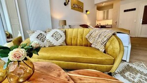 Una sala de estar con un sofá amarillo, una mesa de centro de madera y un jarrón con una flor.