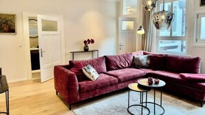 Ein modernes Wohnzimmer mit einem roten Sofa, einem kleinen runden Tisch und Pendelleuchten.