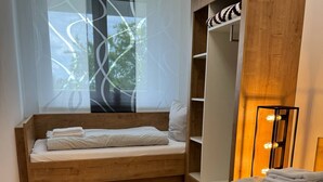 Een moderne slaapkamer met een ingebouwde bank, een groot raam met uitzicht en een nachtkastje met een lamp.