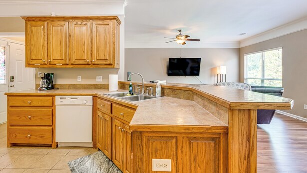 A kitchen with wooden cabinets, a dishwasher, a sink, and a ceiling fan. - 11 Mi to Dtwn Little Rock: Home w/ Large Deck! (Mabelvale)